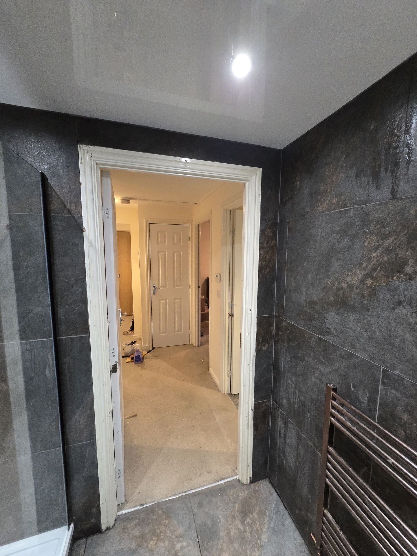 Bathroom doorway and tiling with copper towel rail