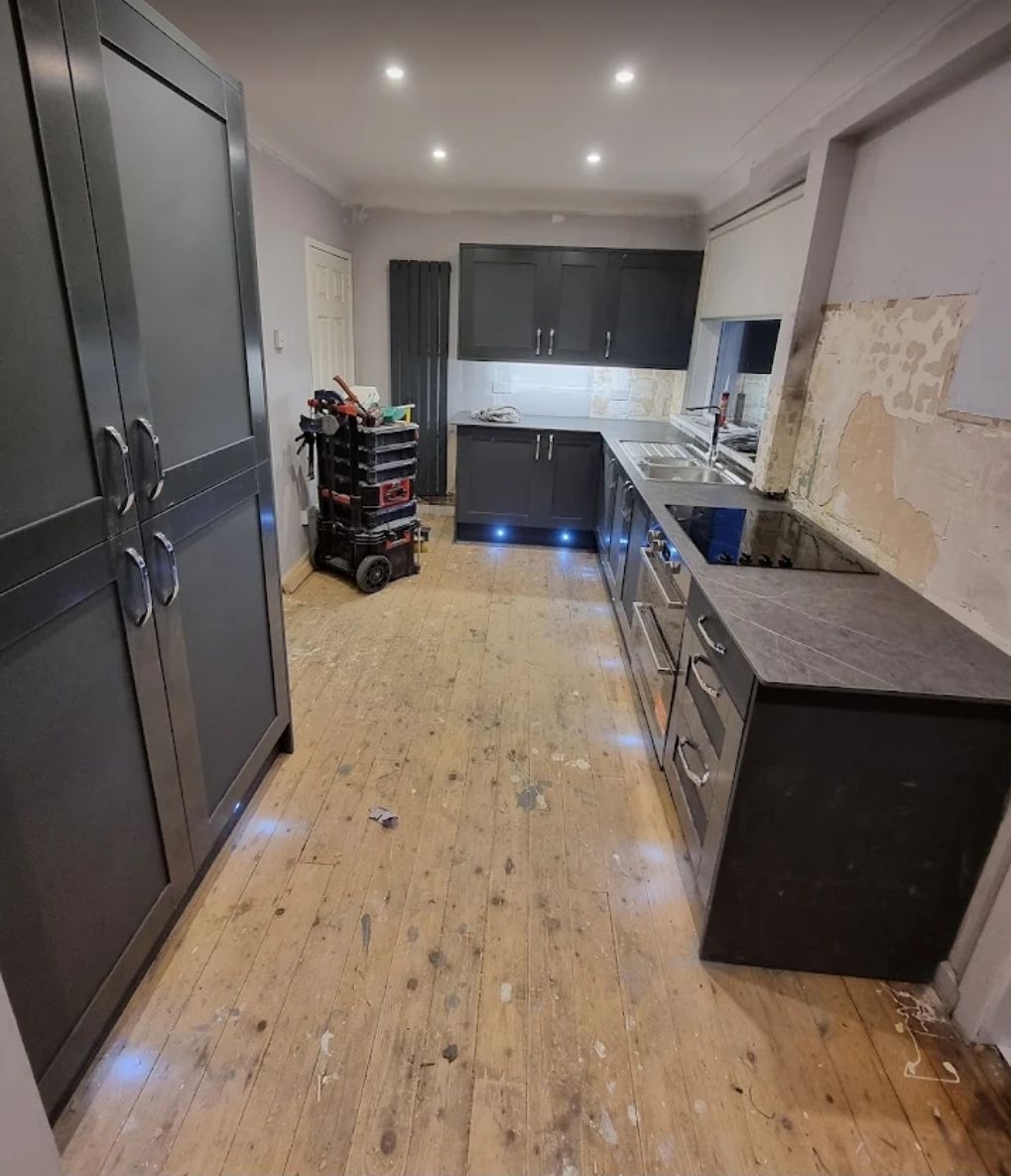 Grey kitchen cabinets with LED plinth lighting installation